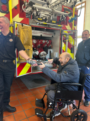 Resident holding hose at a fire station